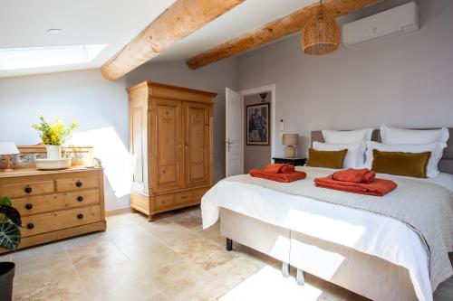 a bedroom with a large bed and a wooden dresser at Chic Converted Stables in Laurens