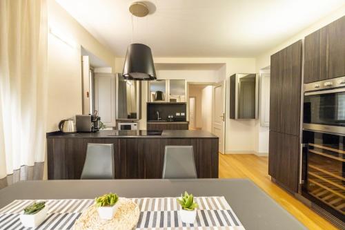 a kitchen and living room with a table and chairs at Piazza Castello 200 sqm - Terrace - Jacuzzi in Turin