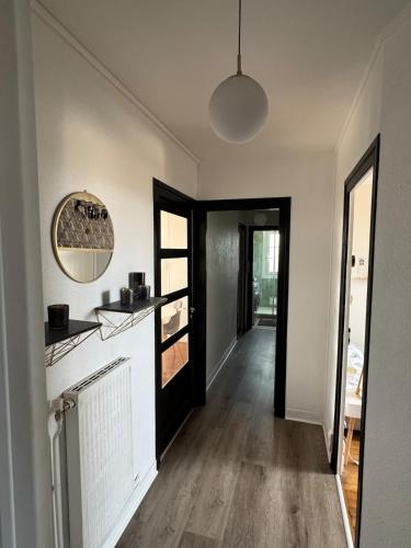 - un couloir d'une maison avec une cuisine et un miroir dans l'établissement L auditorium - Parc des Expositions et Congrès, à Dijon