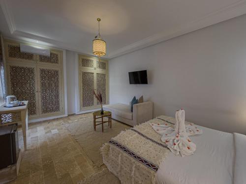 a bedroom with a bed and a living room at Riad Tonaroz Gold in Marrakech