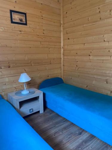 a room with two beds and a lamp on a table at 7 Seas in Wrzosowo