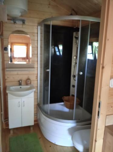 a bathroom with a tub and a sink at 7 Seas in Wrzosowo