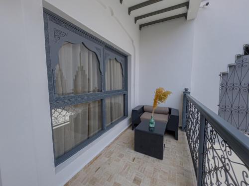 a room with a balcony with a window and a table at Riad Tonaroz Gold in Marrakech