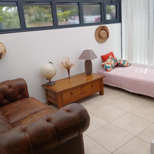 un salon avec un canapé et un lit dans l'établissement la roseraie, à Six-Fours-les-Plages