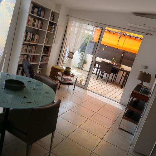 d'un salon avec une table et des chaises ainsi que d'une terrasse. dans l'établissement la roseraie, à Six-Fours-les-Plages