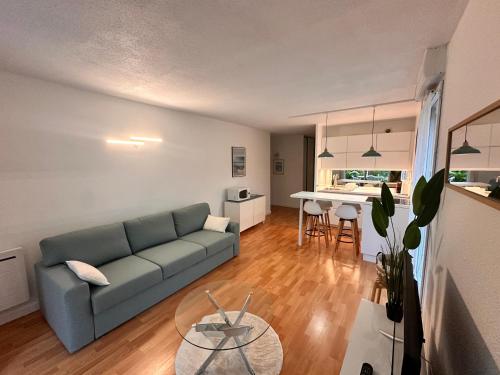 un salon avec un canapé et une table dans l'établissement magnifique T2 vue sur parc, à Capbreton
