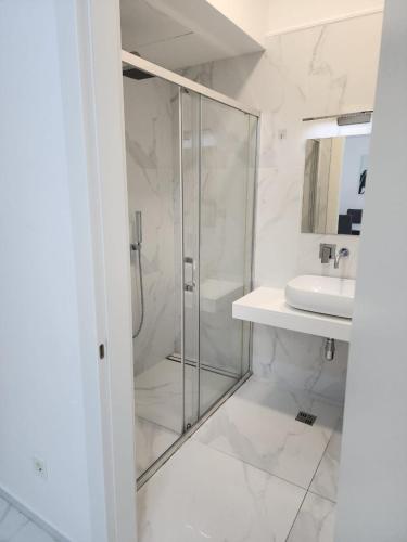 a bathroom with a glass shower and a sink at Apartment Del Mare in Boreti