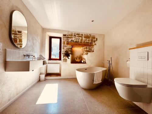 a bathroom with a tub and a sink and a mirror at La Nine in Aigne