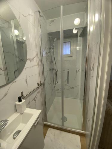 une salle de bain avec douche et lavabo dans l'établissement DISNEY LOVE - VAL D EUROPE - Vallée Village - VILLAGE NATURE - PARC ASTERIX, à Carnetin