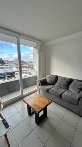 a living room with a couch and a coffee table at Edificio león Gallo in Temuco
