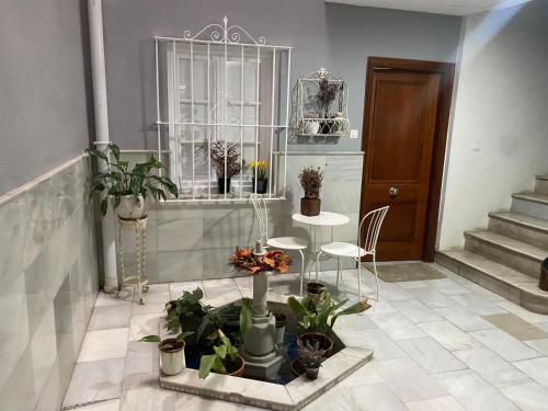 a room with a table and chairs and potted plants at Escapada junto a Picasso in Málaga