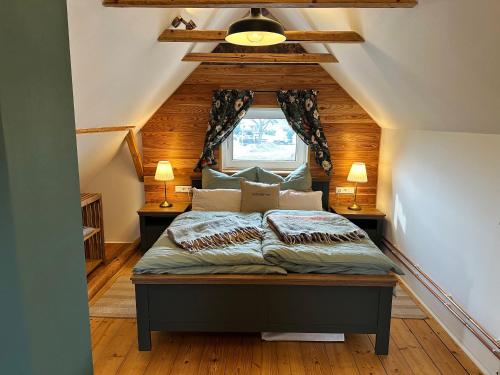 a bedroom with a bed in a attic at Ferienhaus KellerwaldChalet in Jesberg mit großem Garten zur Alleinnutzung in Jesberg