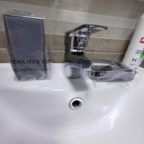 a bathroom sink with a faucet on a white sink at LARI Apartment in Subotica