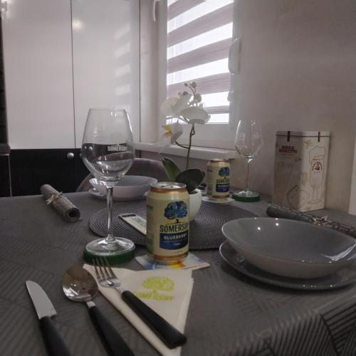 a table with a table cloth with a glass of wine at LARI Apartment in Subotica