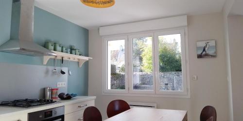 une cuisine avec une fenêtre, une table et des chaises dans l'établissement Retour de plage, à Regnéville-sur-Mer