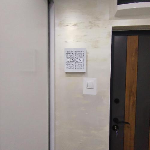 a sign on a wall next to a door at LARI Apartment in Subotica