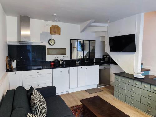 un salon avec un canapé et une cuisine dans l'établissement Charmant cocon avec terrasse à 2 pas du vieux port, à La Rochelle