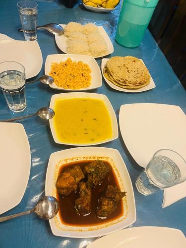 Una mesa cubierta con platos y cuencos de comida en Ohiya Alpine River Lodge, en Ohiya