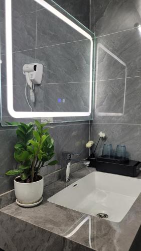 a bathroom with a white sink and a mirror at Trang An by Linh Homestay in Nguyên Ngoại