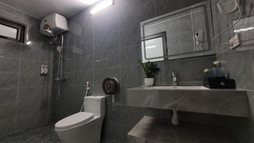 a bathroom with a toilet and a sink and a mirror at Trang An by Linh Homestay in Nguyên Ngoại