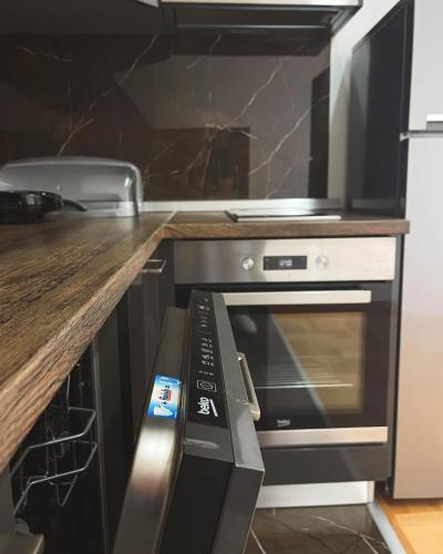 a kitchen with a stove and a microwave at Apartmani TEO in Prokuplje