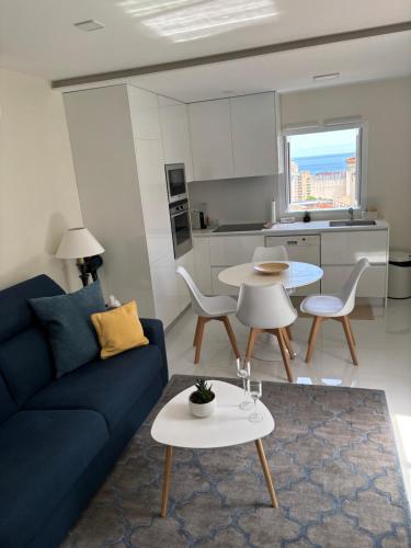 a living room with a blue couch and a table at Logement aux portes de Monaco Cap D Ail in Cap d'Ail