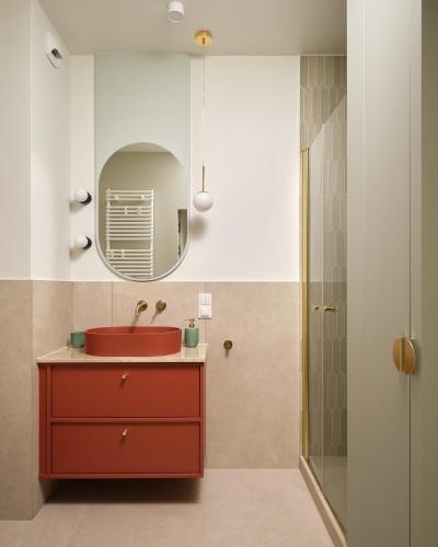 a bathroom with a red sink and a mirror at Luxury Art Apartment Wrocław in Wrocław