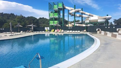 une grande piscine avec un toboggan aquatique dans l'établissement Mobile Home Climatisé 3 chambres à Narbonne Plage, à Narbonne-Plage
