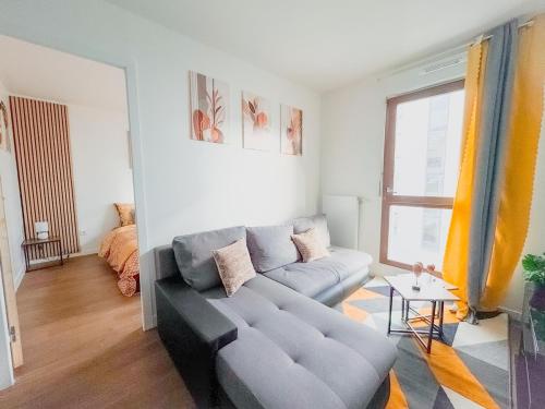 un salon avec un canapé et une table dans l'établissement Elegancia Stade de France, proche Paris, à Pierrefitte-sur-Seine