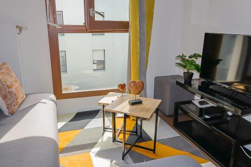 un salon avec un canapé et une télévision dans l'établissement Elegancia Stade de France, proche Paris, à Pierrefitte-sur-Seine