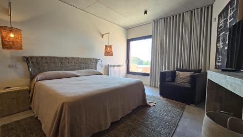 a bedroom with a bed and a chair and a television at Villa São Roque in Ponta Delgada