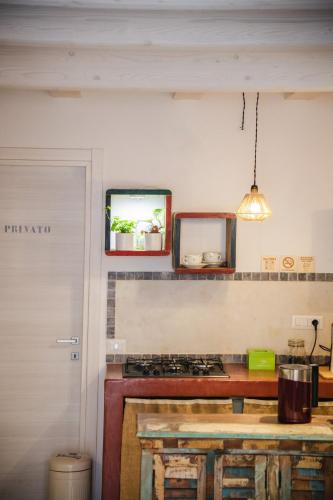a kitchen with a stove and two mirrors on the wall at B&B Terra - Stanza Viaggio in Carloforte