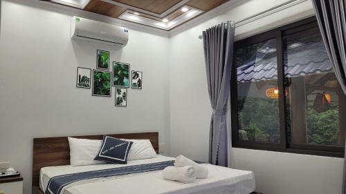 two beds in a room with a window at Trang An by Linh Homestay in Nguyên Ngoại