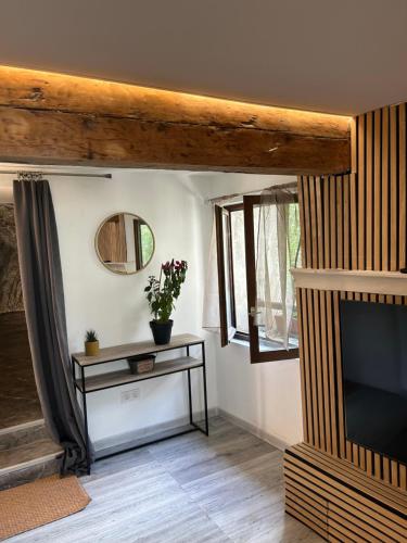 un salon avec une télévision et une table dans l'établissement Appartement avec jacuzzi, à Sisteron