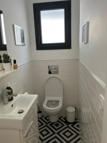 une salle de bain avec des toilettes blanches et un lavabo dans l'établissement Chambre privée Fer à cheval, à Toulouse