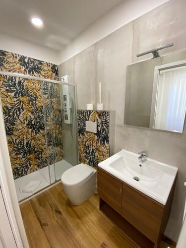 a bathroom with a sink and a shower and a toilet at Begonia Apartment in Rome