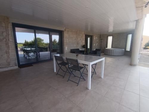 Cette chambre dispose d'une terrasse avec une table et des chaises blanches. dans l'établissement Appartement moderne, à Pia