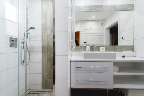 a white bathroom with a sink and a shower at Serce Pienin in Jaworki