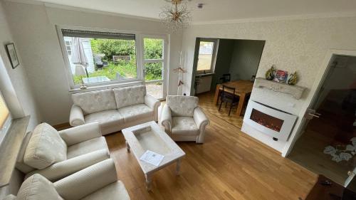 a living room with a white couch and a fireplace at Ferienhaus An der Weinrebe in Bad Hersfeld mit Garten, 2 Bäder, 2 Schlafzimmer & Küche - gratis Parkplätze in Bad Hersfeld