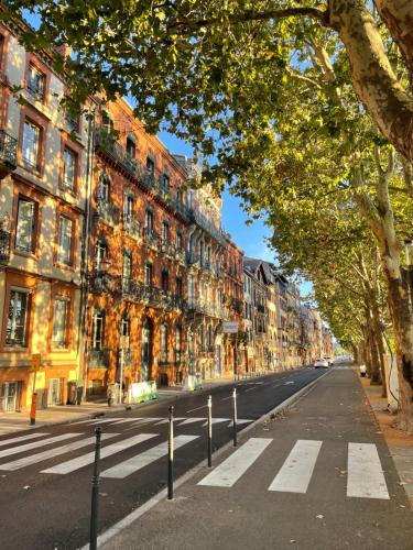 une rue vide dans une ville avec des bâtiments et des arbres dans l'établissement Appartement place du Fer à Cheval, à Toulouse