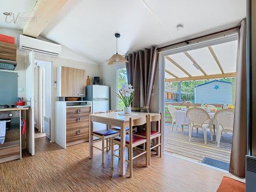une cuisine et une salle à manger avec une table et des chaises dans l'établissement Grand Mobil home 3chbr 2sdb camping La Carabasse, à Vias