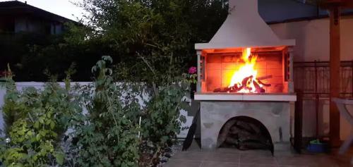 a fireplace with a fire in it in a garden at Tonia's guest house in Sami