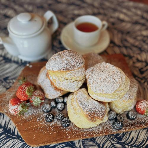 a plate of biscuits and berries and a cup of tea at The Robin Hill in Torquay