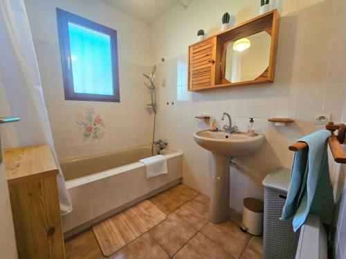 La salle de bains est pourvue d'un lavabo, de toilettes, d'une baignoire et d'un miroir. dans l'établissement Grande maison familiale proche plage Barcarès, au Barcarès