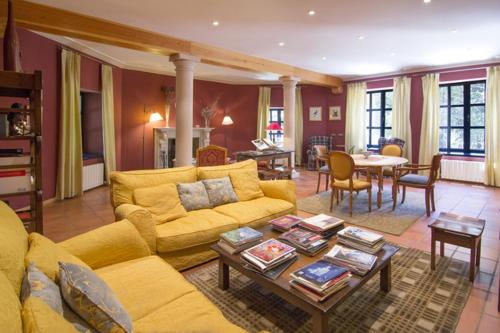 a living room with a yellow couch and a table at Hotel Sara De Ur in La Cabrera
