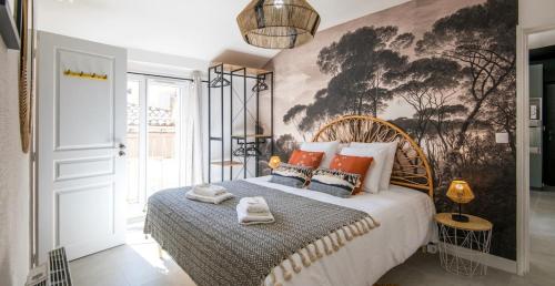 une chambre avec un lit avec un tableau sur le mur dans l'établissement Le Voyage, à Millau