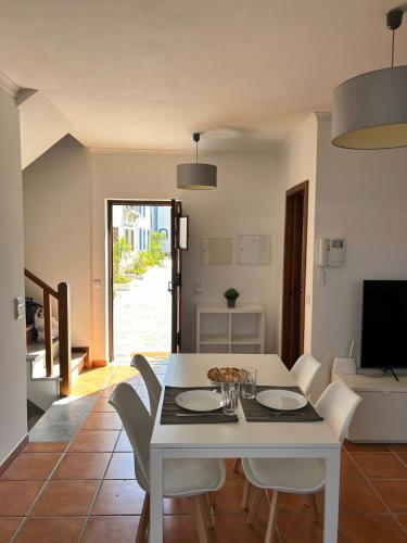 a dining room with a white table and chairs at Alqueva - Casa Da Luz in Mourão