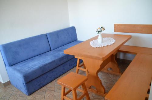 a living room with a blue couch and a table at Apartmaji Srnca in Cerkno