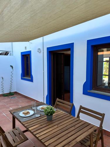 a table and chairs on a patio with blue walls at Alqueva - Casa Da Luz in Mourão