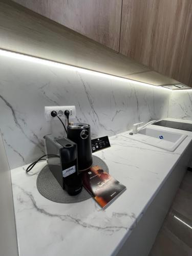 een aanrecht met een koffiezetapparaat en een boek erop bij SIGMA suites in Constanţa